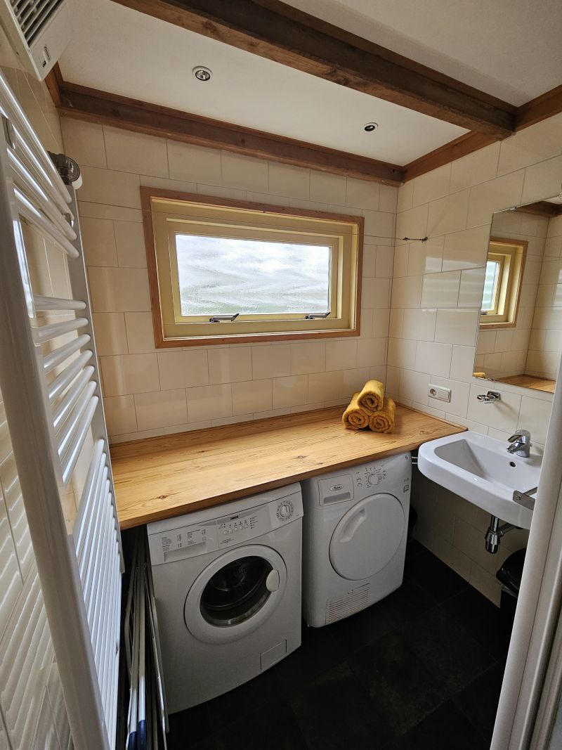 De badkamer, met wasmachine en droger