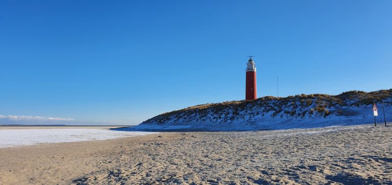 Het strand bij de vuurtoren in de winter